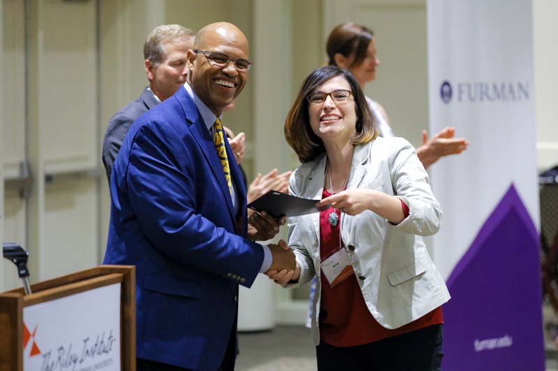 Anna Padaetz, A S.E.A.T. at the Table, receiving her Riley Fellow certificate from Juan Johnson
