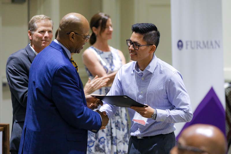 Trung Phan, A S.E.A.T. at the Table, receiving his Riley Fellow certificate from Juan Johnson