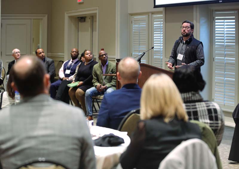 (l-r) Gary Clary, Jermaine Taylor, Chris Briddell, Allison Mertens, Roxanne James, Jerry Blassingame, Executive Director, Soteria Community Development Corporation, and Kevin Estep speaking, Reclaimed