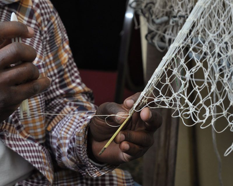 His grandson demonstrating the process of weaving the cast net