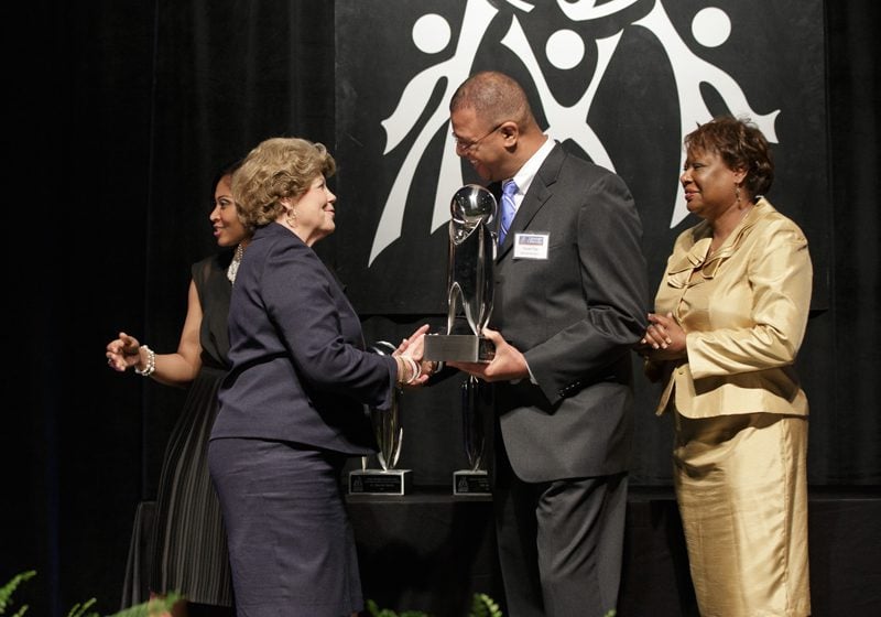 Randall Trigg, Manager of Procurement for BMW Manufacturing Co., presenting the Outstanding Non-Profit Organization award to Bon Secours St. Francis Health System (accepted by Camilla Hertwig and Maxim Williams); the award was sponsored by BMW Manufacturing Co.
