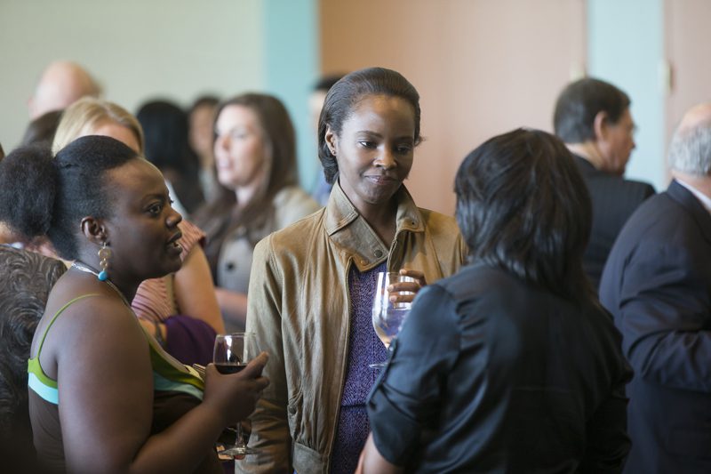 Kiara Kabukuru (center) and her sister (left) talking with guests