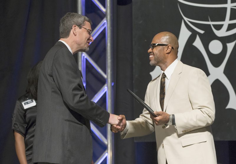 Juan Johnson presenting the Honorable Mention Outstanding Individual Award to David Taylor, Executive Director of Momentum Bike Clubs.