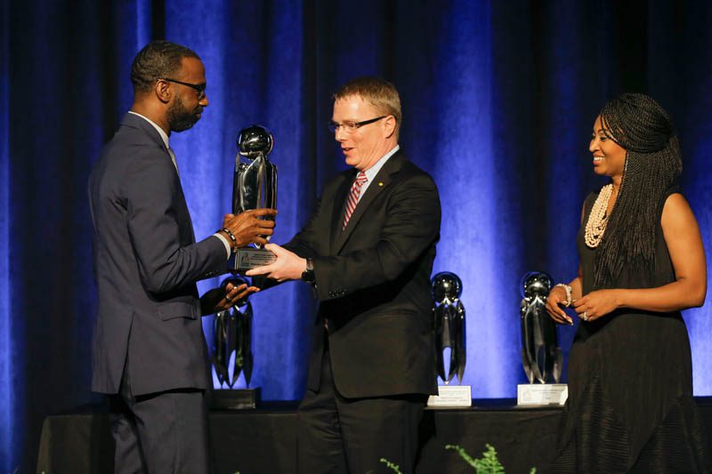 Robert Verostek, Senior Vice President of Finance with Denny’s Corporation presenting the William “Bill” T. Wylie Valued Lives Award for School Excellence in Diversity to Damon Qualls, principal of Monaview Elementary School