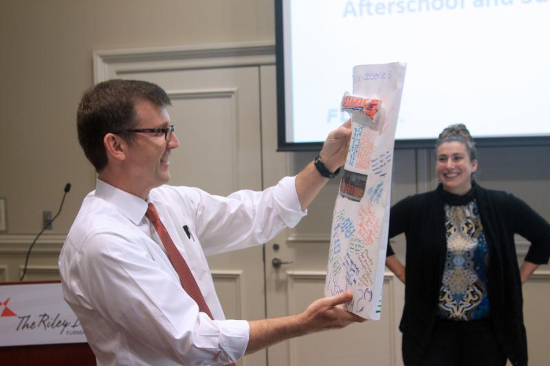 Fellow Kelly Malone presenting facilitator Ron Fairchild with a special gift