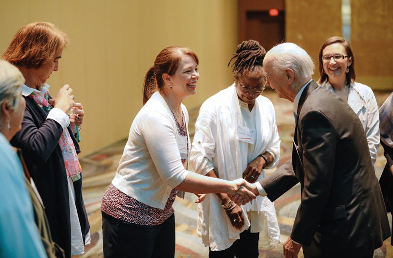 Secretary Riley shaking hands with Kari Maastricht with the Engaging Creative Minds' team