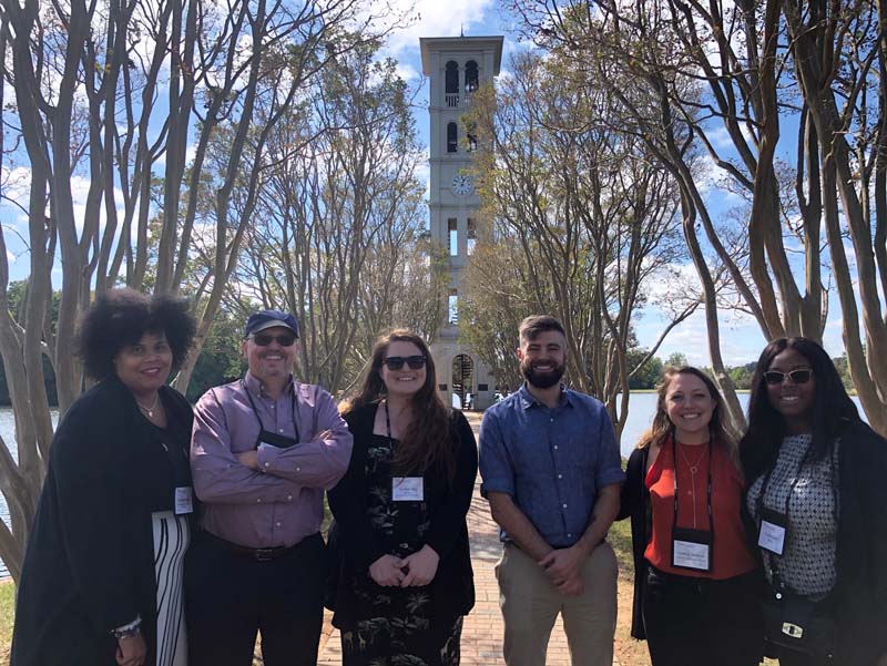 (l-r) Tyneisha Gibbs, Jeff McConaughy, Heather May, Brent Balog, Heather Williams and Tiyana Glenn by Furman's iconic Bell Tower