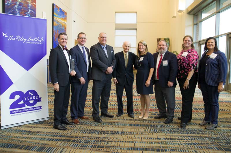 Award winner Carolina Teacher Induction Program. (l-r): Jon Pedersen, Thomas Hodges, Jamie Hennessy, Secretary Riley, Nicole Skeen, Morgan Lee, Angela Adams and Cindy Van Buren