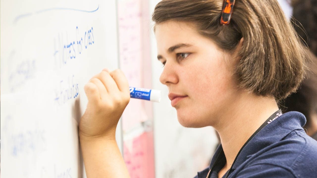 Student writing on whiteboard