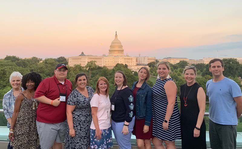 Teachers of Government participants stand in front of the U.S. Capitol building as the sun sets