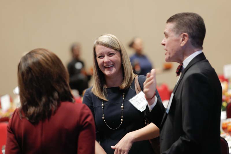 Nicole Skeen (c), College of Education, University of South Carolina, and Jon Pedersen (r) speaking with a guest