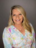 Head shot of a woman in a printed shirt.