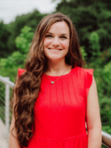 Head shot of a woman wearing red.