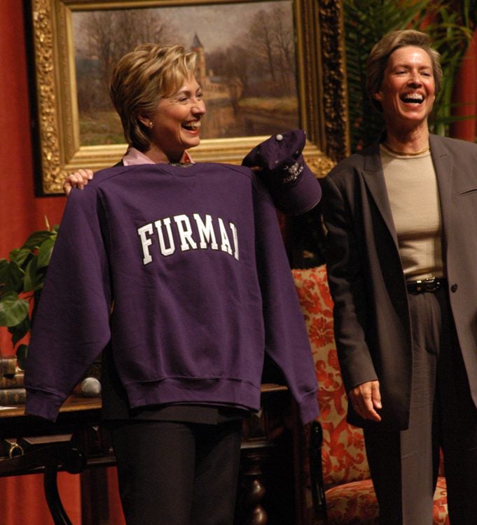 Senator Clinton displays a souvenir Furman sweatshirt and hat