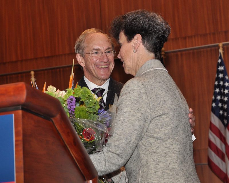 Rod Smolla presenting a bouquet of flowers to Paula Harper Bethea for her dedication to the Wilkins Awards event