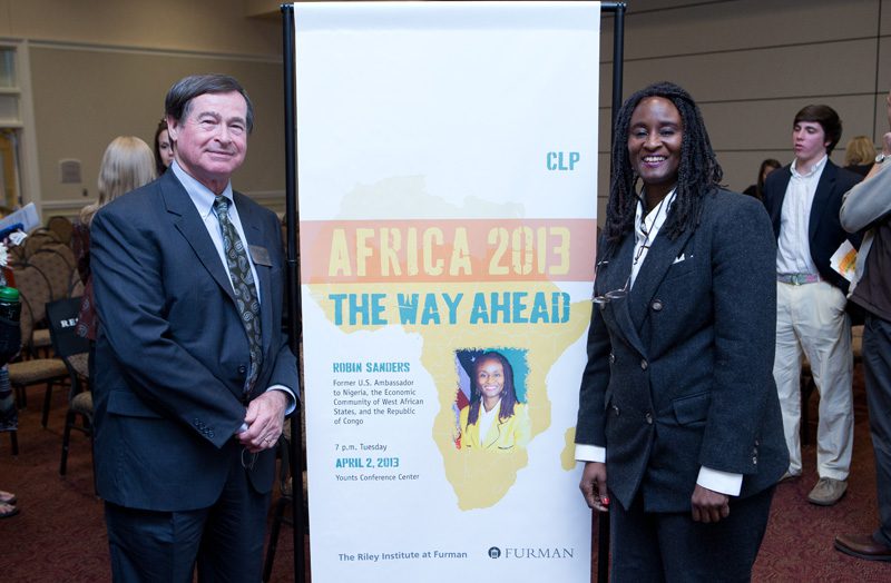 Don Gordon and Ambassador Sanders on each side of the event banner