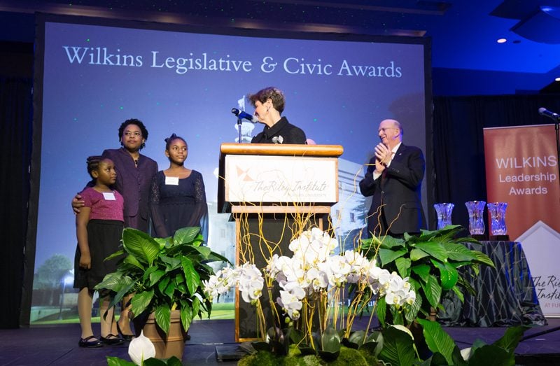 Mrs. Jennifer Pinckney, accepting the award, along with her daughters, Eliana and Melana