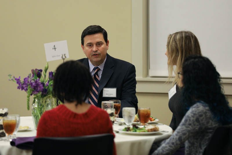 Mark Quinn, moderator of the Climate Change conference, speaking with students at his table