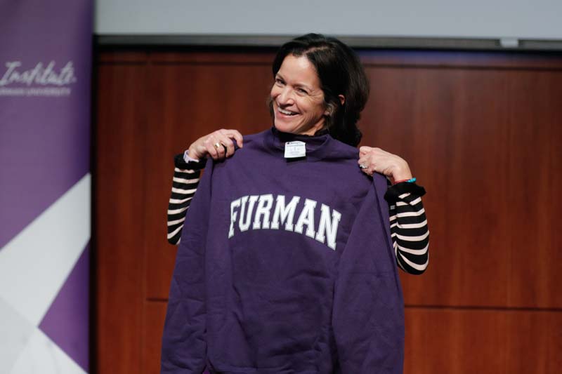 Angela Maria Kelley showing the audience her gift, a Furman sweatshirt