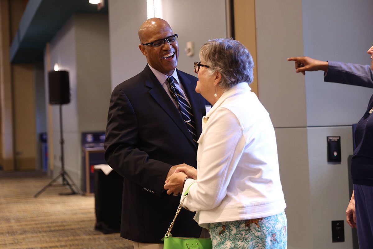 Juan Johnson, Diversity Leaders Initiative facilitator, greets graduates of the program at the door. The event was attended by many Riley Fellows from across the state.