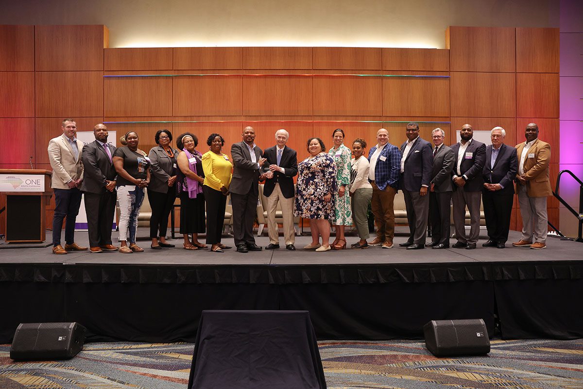 Those involved with the Northside Initiative stand on stage as the initiative is honored with the OneSouthCarolina Partners in Progress Award.