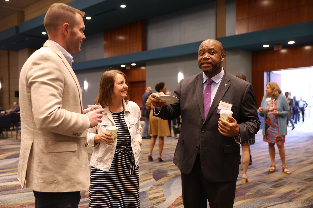 Michael Williamson, president and CEO of Northside Development Group, and Mitch Kennedy, assistant city manager of City of Spartanburg, speak with an eventgoer prior to the start of the event.
