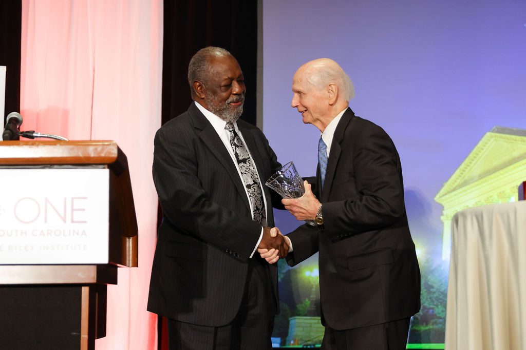 Secretary Dick Riley presents Roland Gardner with the 2023 Riley-Wilkins OneSouthCarolina Civic Leadership Award. 