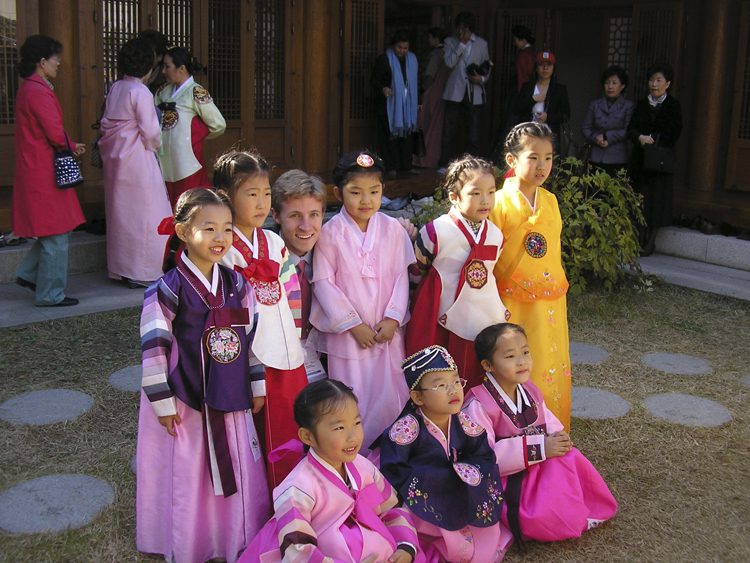 Chris Schoen with traditionally-dressed Korean children