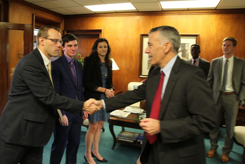 Economics professor Jason Jones meets Ambassador Goldberg upon the group's arrival at the embassy