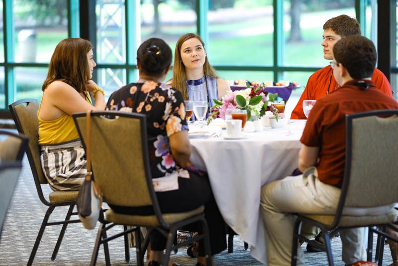 The scholars converse with Dr. Shaniece Criss during the Welcome Dinner at the start of the Advantage Scholars program
