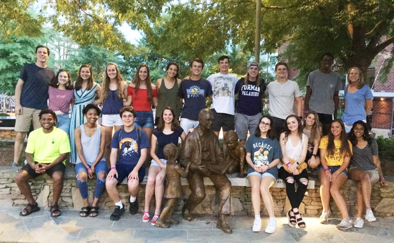 Group photo downtown around sculpture of Secretary Riley