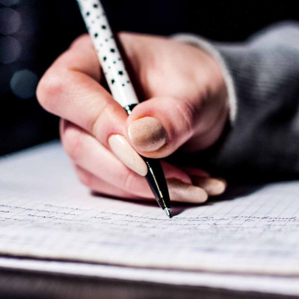 Woman's hand writing on a notepad
