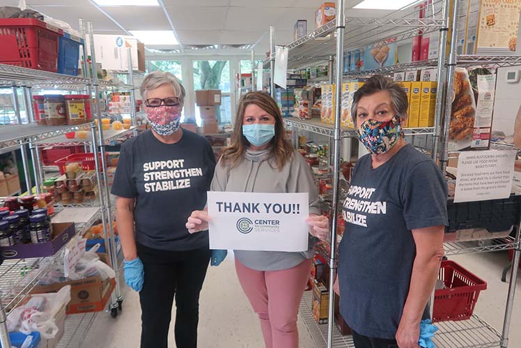 Center for Community Service volunteer holding thank you sign