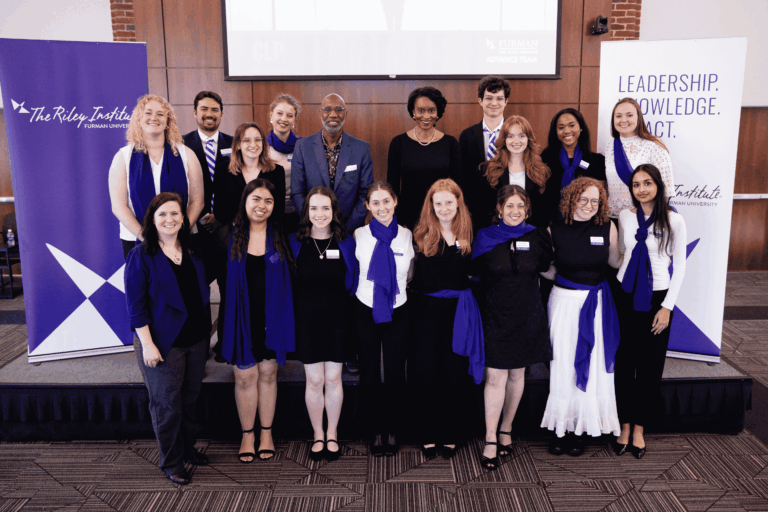 Group of students and speakers lined up in two rows, posing