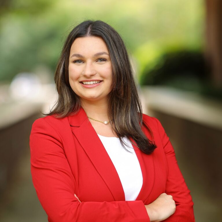 A girl in a red jacket crossing her arms