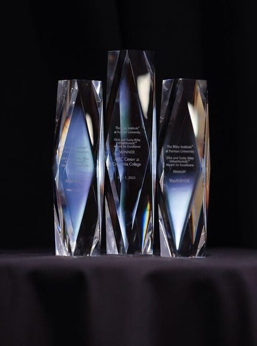 Three crystal awards against a black backdrop