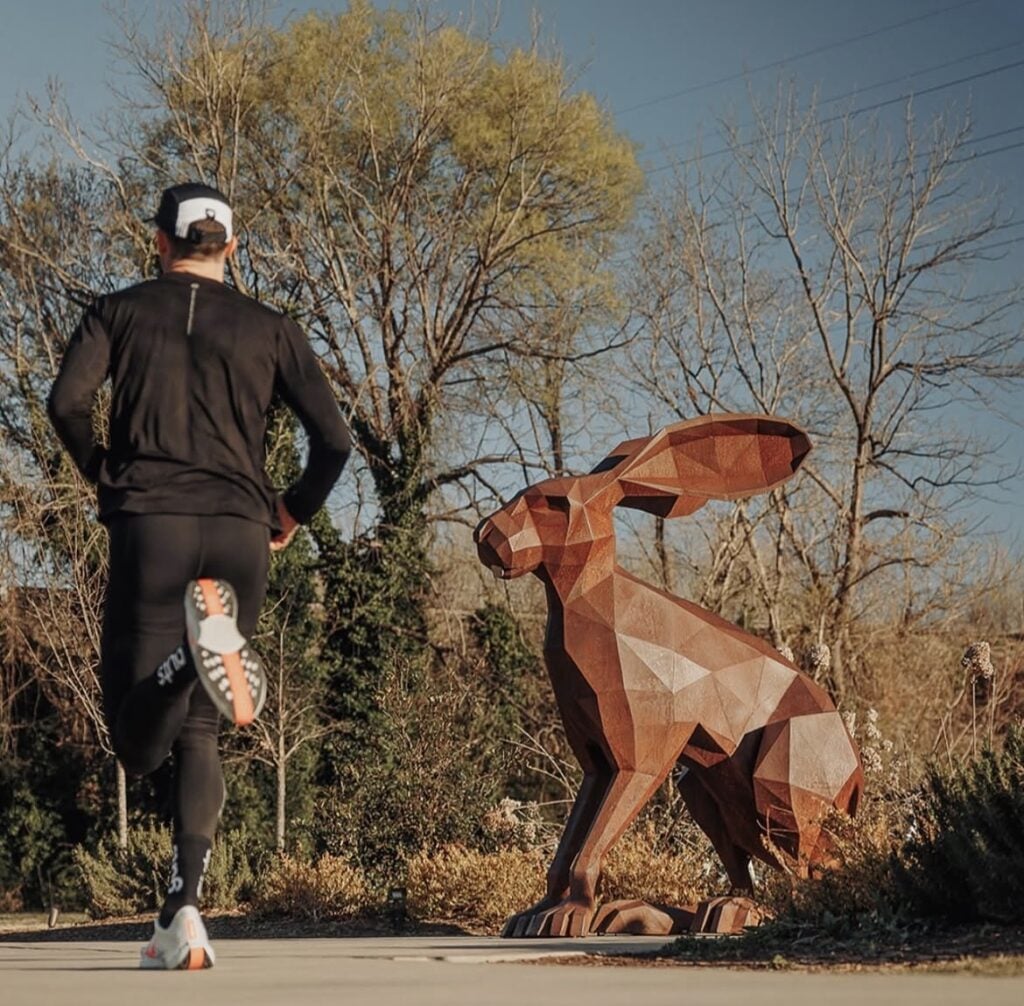 Man running near large rabbit statue