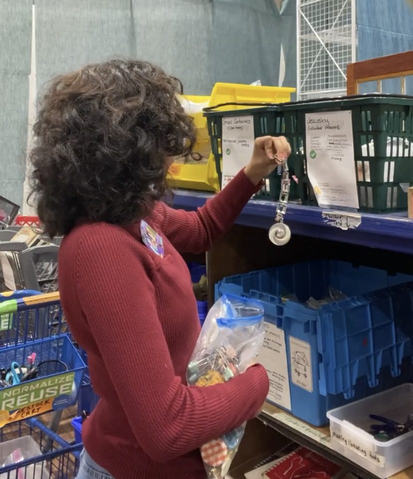 Student sorts jewelry donations at ReCraft store.