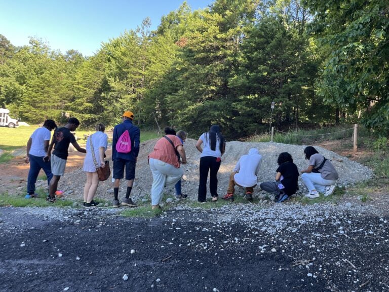 Several students looking at rock pile