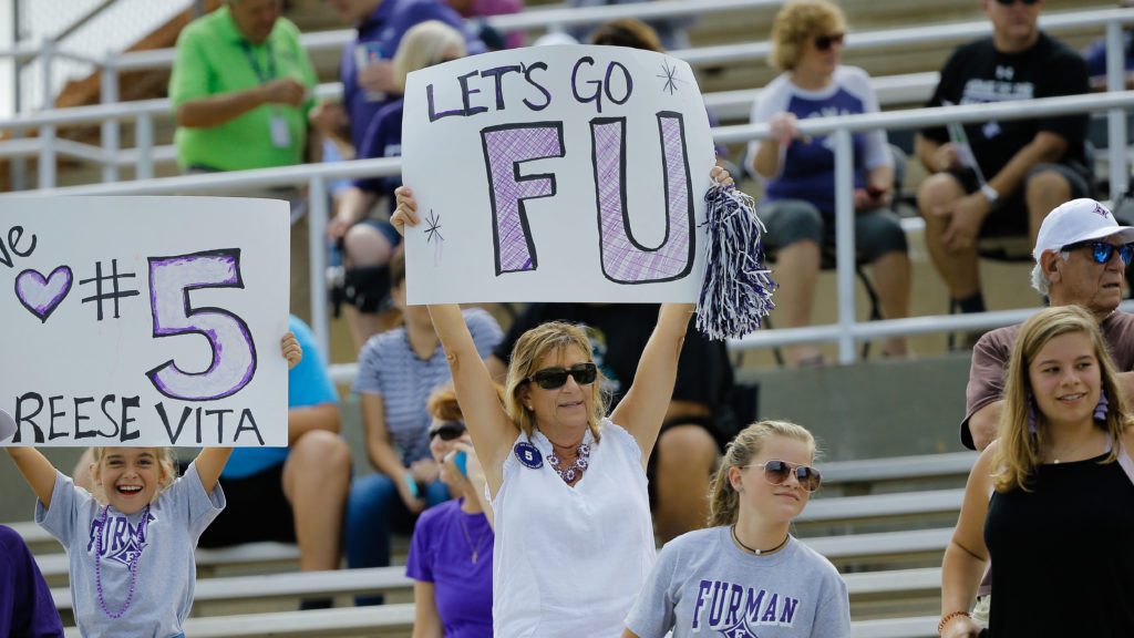 Mother holding Furman sign during game