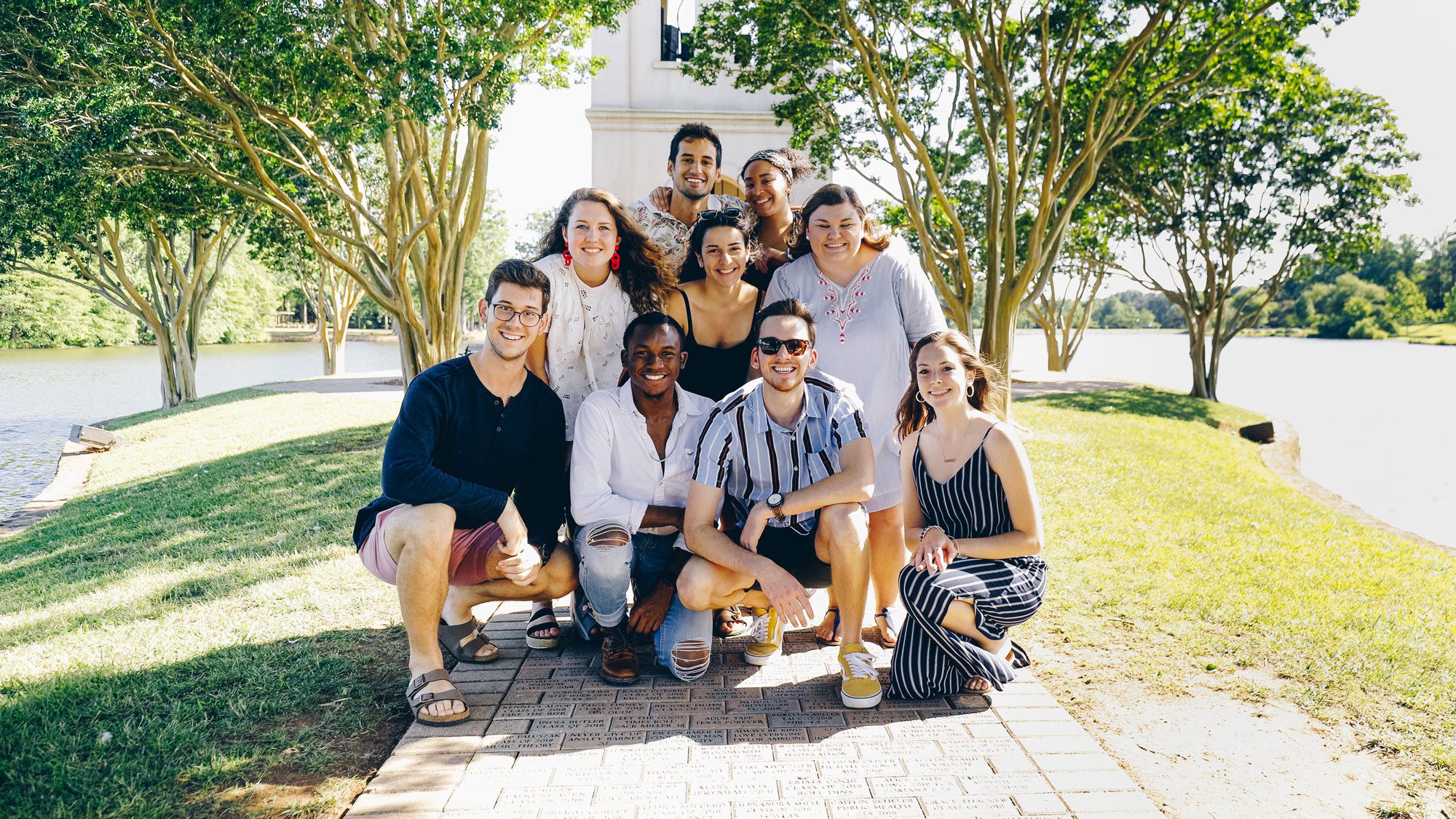 Students standing in front of bell tower, Orientation Staff pictured