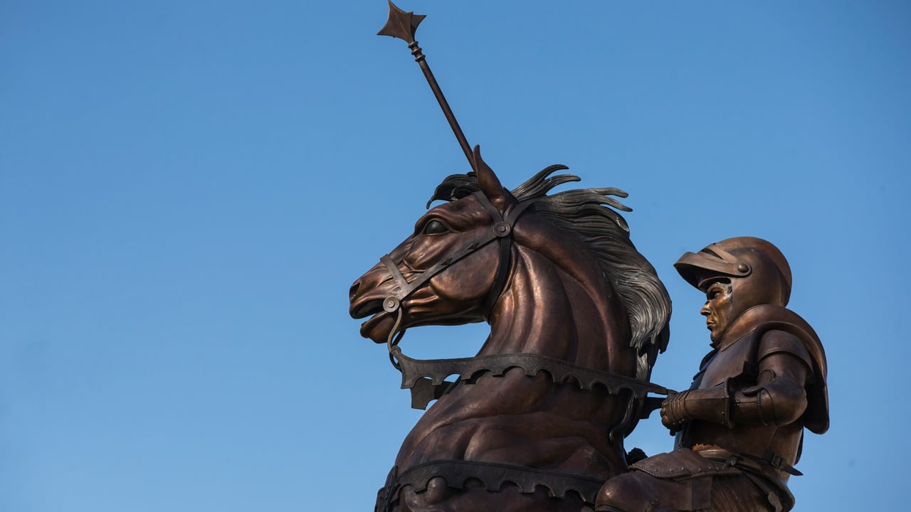 Rearing horse statue against blue sky