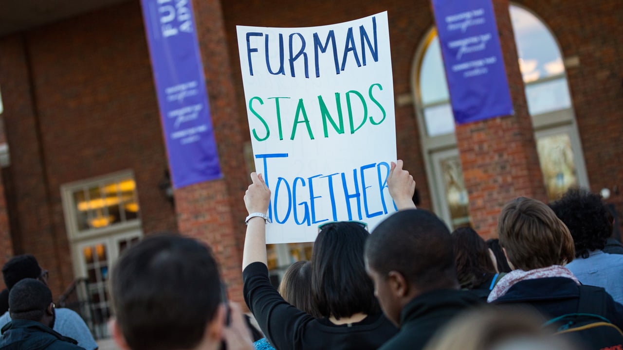 Student holding diversity sign