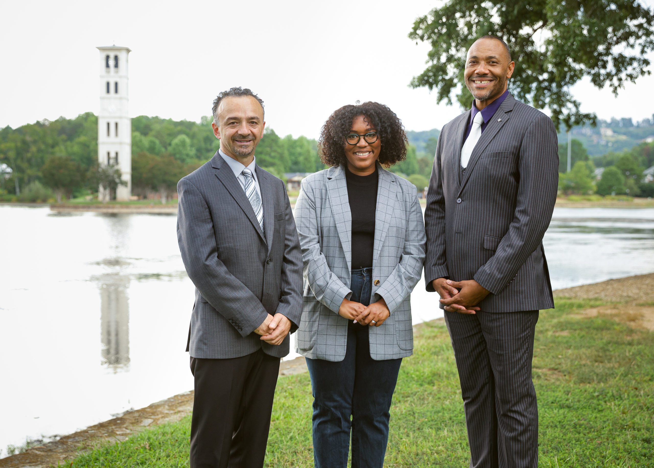 Center for Inclusive Communities staff standing in front of lake and bell tower.
