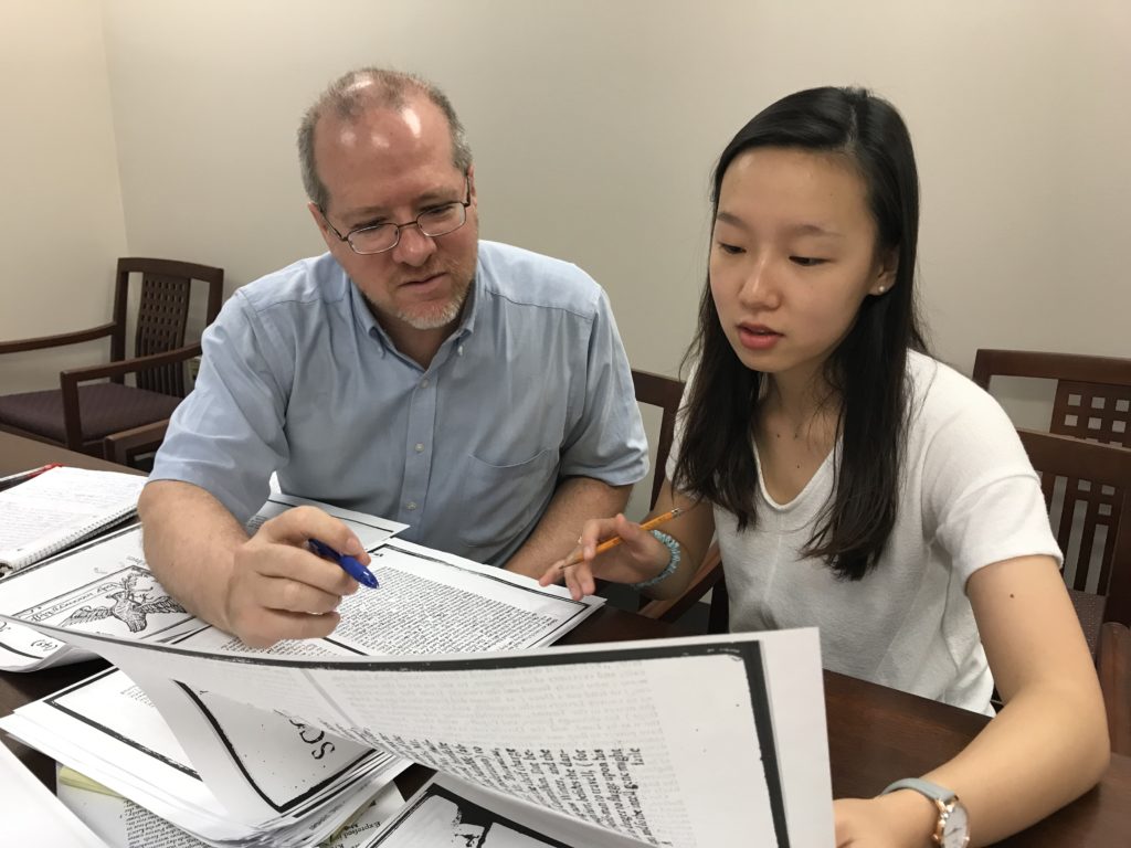 Student working with professor on articles