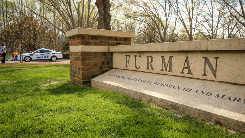 Furman University entrance sign with police vehicle in background