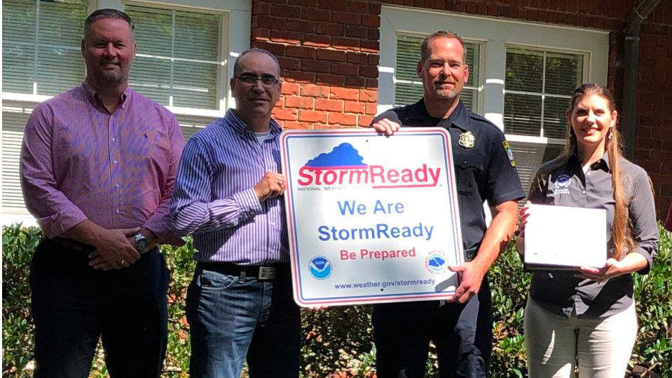 Storm Ready sign, held by police officer