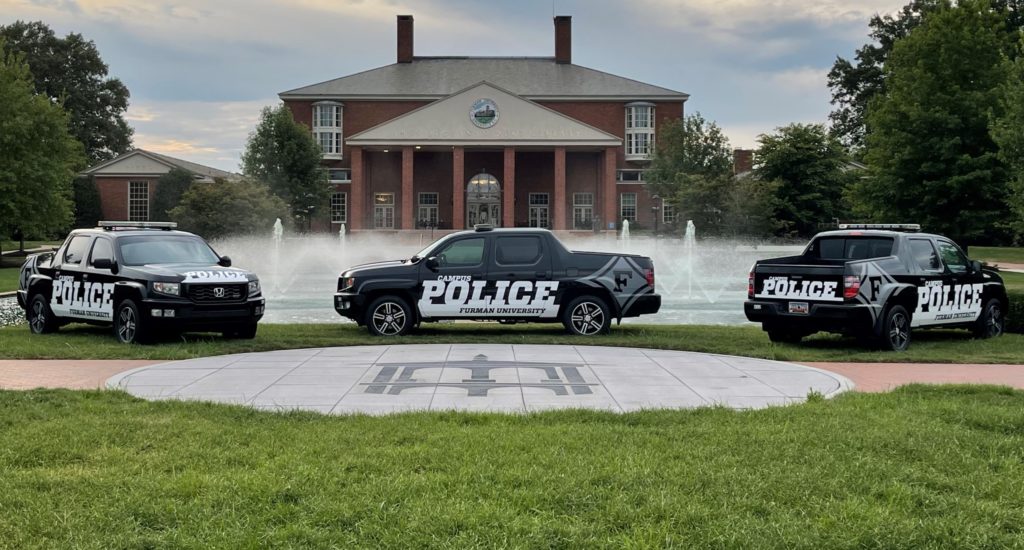 Newly wrapped Furman Police vehicles in front of the fountains and the Library