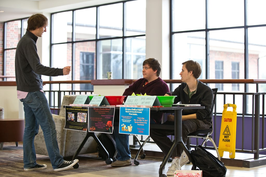 Three men talking in Furman's Trone Student Center